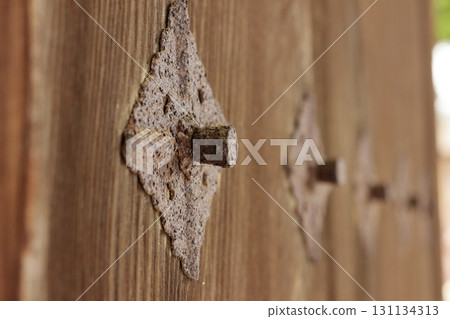 Rusty metal fittings on the wooden gate of a temple 131134313