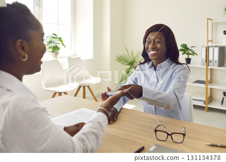 A happy, smiling woman receiving her salary payout or borrowing a cash money loan 131134378