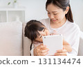 Mother and 3-year-old girl tablet 131134474
