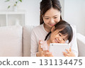 Mother and 3-year-old girl tablet 131134475