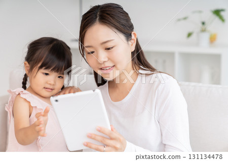 Mother and 3-year-old girl tablet 131134478
