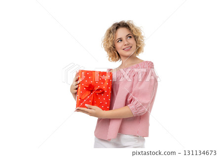 Woman joyfully shows a colorful gift box, isolated on white, PNG Woman joyfully shows a colorful gift box, isolated on white, PNG 131134673