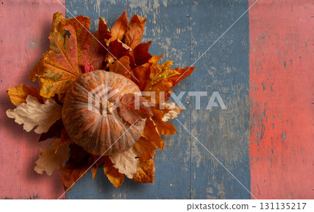 Rustic Autumn Display of Pumpkin and Colorful Leaves on Wooden Background. File with Clipping Path. 131135217