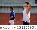 Two asian athlete men are standing leisurely on the racetrack in sports stadium. 131135951