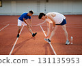 Two asian athlete men are stretching their legs and foots together on the racetrack in sports stadium. 131135953