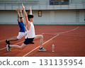 Two asian athlete men are stretching their arms and legs together on the racetrack in sports stadium 131135954