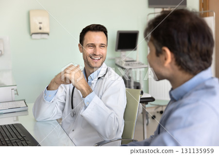 Friendly middle aged doctor hold casual conversation with male patient 131135959