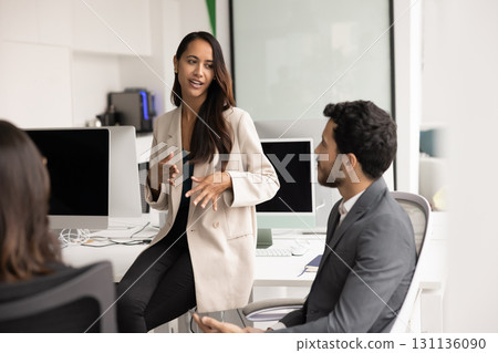 Successful business professional woman discussing product management plan with coworkers 131136090