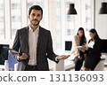 Positive young Middle Eastern business professional man holding copy space 131136093