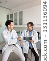 Two doctors holding tablet clipboard shake hands in hospital office 131136094