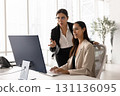 Two diverse business colleagues meeting at computer monitor 131136095