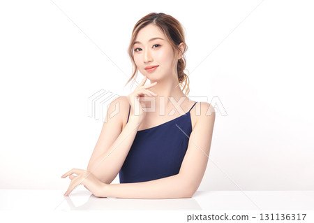 A beautiful young Asian woman with clean, fresh skin against a white background. Skincare, facial treatment, cosmetology, beauty, and spa. An elegant portrait of an Asian woman. 131136317