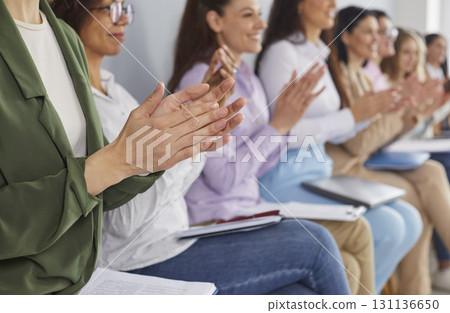 Happy audience clapping hands after a speech at a public business conference or seminar Happy audience clapping hands after a speech at a public business conference or seminar 131136650
