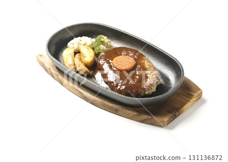 Hamburger steak plate with side dishes of fries, potato salad, and broccoli photographed against a white background 131136872