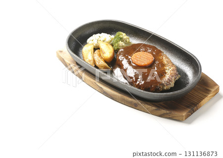 Hamburger steak plate with side dishes of fries, potato salad, and broccoli photographed against a white background 131136873