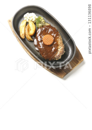 Hamburger steak plate with side dishes of fries, potato salad, and broccoli photographed against a white background Hamburger steak plate with side dishes of fries, potato salad, and broccoli photographed against a white background 131136898