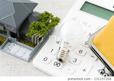 A light bulb, a calculator, a wallet, and a miniature house A light bulb, a calculator, a wallet, and a miniature house 131137208