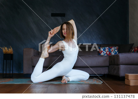 one woman doing in One Legged King Pigeon yoga pose at home one woman doing in One Legged King Pigeon yoga pose at home 131137478