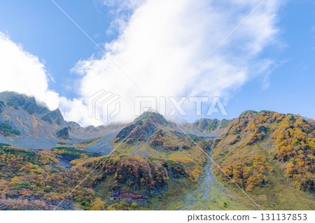 [Autumn leaves] Scenery of Karasawa Cirque with clouds forming as autumn leaves reach their peak [Nagano Prefecture] 131137853