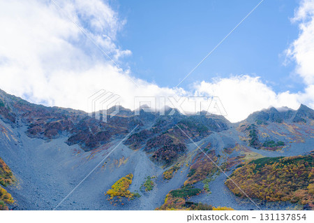 [Autumn leaves] Scenery of Karasawa Cirque with clouds forming as autumn leaves reach their peak [Nagano Prefecture] 131137854