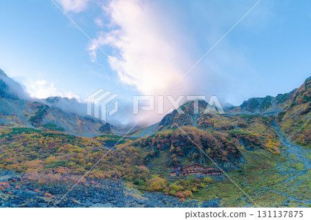 [Autumn leaves] Scenery of Karasawa Cirque with clouds forming as autumn leaves reach their peak [Nagano Prefecture] 131137875