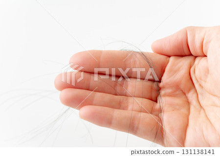 Close-up of hair in the palm of a hand on a white background Close-up of hair in the palm of a hand on a white background 131138141
