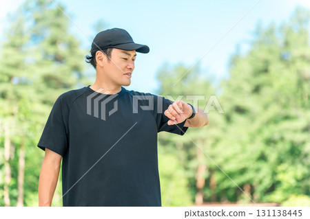 A middle-aged man in sportswear using a smartwatch to manage his health and health care 131138445