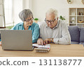 Senior couple sitting at the table and calculating finances or taxes at home. 131138777