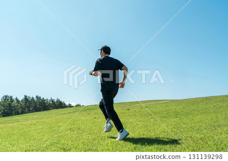 A man running/jogging under a blue sky (athlete/aerobic exercise/workout/fitness) 131139298