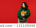 Woman holding paper bag full of fresh tangerines 131139348
