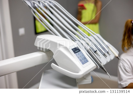 Surgery instruments are neatly organized in a contemporary dental clinic setting, highlighting cleanliness and precision. 131139514