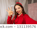 Teen girl smiling taking selfie showing okay hand gesture. 131139576