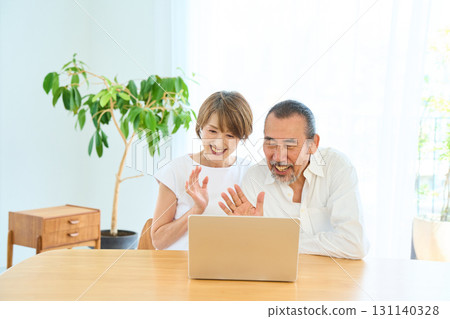 A middle-aged couple making a video call A middle-aged couple making a video call 131140328