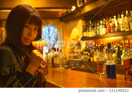 一位女士獨自在正宗的酒吧喝酒 一位女士獨自在正宗的酒吧喝酒 131140922