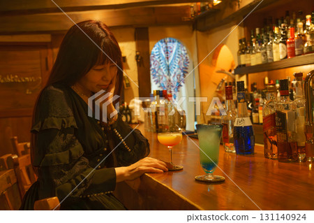 一位女士獨自在正宗的酒吧喝酒 131140924