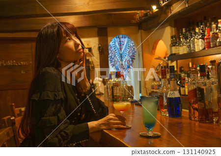 一位女士獨自在正宗的酒吧喝酒 131140925
