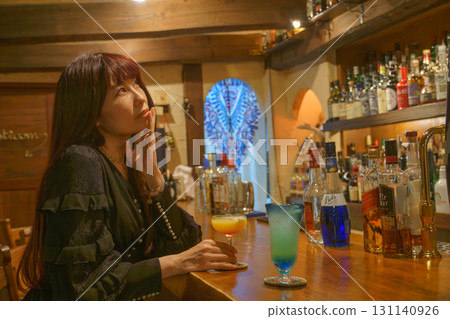 一位女士獨自在正宗的酒吧喝酒 131140926