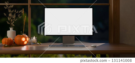 White screen computer and jack-o-lantern halloween pumpkins and candles on wooden table aside window White screen computer and jack-o-lantern halloween pumpkins and candles on wooden table aside window 131141008