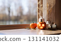Glowing jack-o-lantern pumpkin halloween props with candles on wooden table aside window in sunlight 131141032