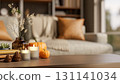 Orange pumpkin halloween props with candles on wooden table aside sofa and window in a living room. 131141034