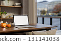 White screen laptop with halloween pumpkin and candle on wooden table aside bookshelf in living room 131141038