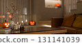 Glowing halloween pumpkin lantern and lighting aroma candle on glass top wooden table in living room 131141039