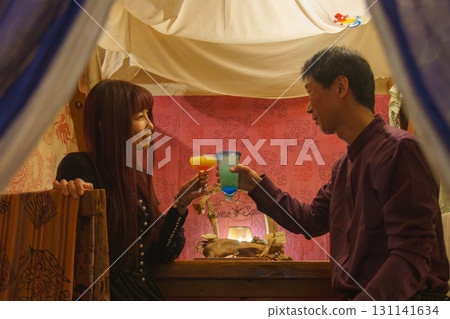 A couple toasting at an overseas resort. Moving abroad with FIRE 131141634