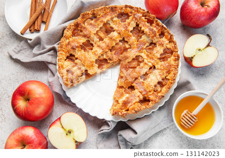 Apple pie with slice removed surrounded by fresh apples 131142023