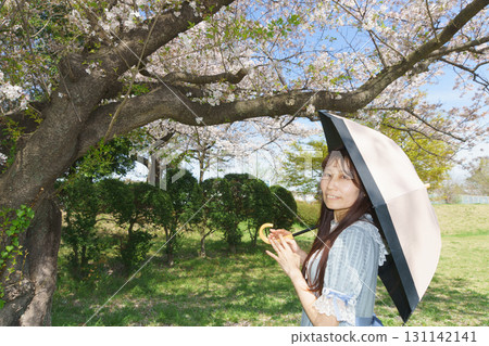 一位日本中年婦女被盛開的櫻花包圍 131142141