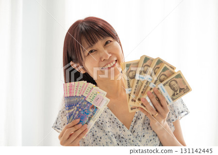 A woman who won a large lottery prize and is holding a stack of new banknotes (Shibusawa Eiichi) 131142445