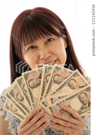 A woman using a stack of new banknotes (Shibusawa Eiichi) as a fan (sensu). A woman using a stack of new banknotes (Shibusawa Eiichi) as a fan (sensu). 131142456