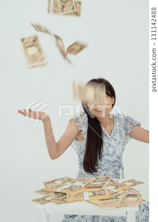 A woman rejoices as 10,000 yen bills fall from a stack of bills A woman rejoices as 10,000 yen bills fall from a stack of bills 131142488