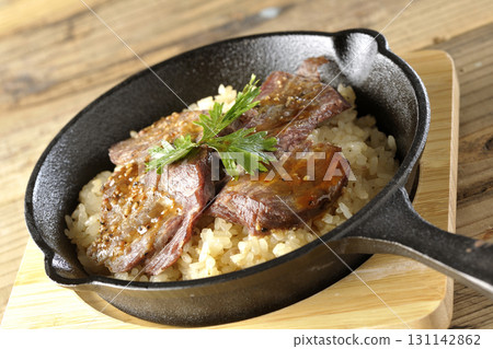 Garlic rice topped with grilled meat 131142862