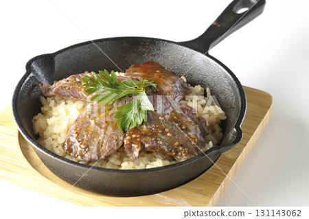 Garlic rice topped with grilled meat photographed on a white background Garlic rice topped with grilled meat photographed on a white background 131143062